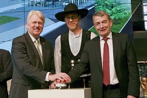 Elf Monate nach der Grundsteinlegung hat das Deutsche Fußballmuseum in Dortmund am 4. April sein Richtfest gefeiert. An der Zeremonie nahmen neben DFB-Präsident Wolfgang Niersbach, Dortmunds Oberbürgermeister Ullrich Sierau, NRW-Sportministerin Ute Schäfer und Bundestrainer Joachim Löw rund 200 Gäste aus Sport, Politik und Gesellschaft teil. Das vom Architektenbüro HPP in Düsseldorf geplante Museumsgebäude soll mit einer stark erlebnisorientierten und multimedialen Dauerausstellung zur deutschen Fußballgeschichte im ersten Halbjahr 2015 eröffnet werden. Die Bauarbeiten befinden sich im Kosten- und Zeitplan.  NRW-Sportministerin Ute Schäfer sagte in ihrem Grußwort: „Das Fußball-Land Nordrhein-Westfalen ist ein hervorragender Standort für das Nationale Deutsche Fußballmuseum. Hier in NRW wird Fußball gelebt und geliebt. Das Museum wird daher ein Aushängeschild für Dortmund, aber auch eine Werbung für den Fußball und das Museumsland Nordrhein-Westfalen sein.“  DFB-Präsident Wolfgang Niersbach äußerte: „Ein großer Dank geht vor allen an die Handwerker, die es mit ihrem Engagement ermöglichen, unsere Idee von einem Heimatort für deutsche Fußballgeschichte zu verwirklichen. Es ist beeindruckend zu beobachten, wie die Vorgaben der Ausstellungskonzeption architektonisch umgesetzt worden sind.“  Dortmunds Oberbürgermeister Ullrich Sierau sagte: „Auf der Baustelle wurden etliche Arbeitsstunden unter Flutlicht absolviert. Das passt ja gut zum Thema Fußball und dokumentiert eindrucksvoll den großartigen Einsatz der Beteiligten. Das Gebäude des Deutschen Fußballmuseums fügt sich schon jetzt wunderbar in die Kunst- und Kulturmeile ein.“  Die Stadt Dortmund hatte im Rahmen der Standortvergabe für das Fußballmuseum das Grundstück in zentraler Innenstadtlage zur Verfügung gestellt. Seitens des Deutschen Fußball-Bundes fließen Mittel aus dem Überschuss der WM 2006 und Sponsorengelder in Höhe von zusammen 17,5 Millionen Euro in das Projekt ein. Die Förderung des Landes Nordrhein-Westfalen beträgt 18,5 Millionen Euro, insgesamt belaufen sich die Baukosten auf die auch ursprünglich veranschlagten 36 Millionen Euro.   Bauherrin ist die gemeinnützige DFB-Stiftung Deutsches Fußballmuseum, deren Gesellschafter zu gleichen Teilen die Stadt Dortmund und der DFB sind. Der Rohbau mit einer Bruttogeschossfläche von 7.700 Quadratmetern entstand mit Einsatz von insgesamt 4.000 Kubikmetern Beton und 800 Tonnen Stahl. Bis zum Jahresende sollen die Dach- und Fassadenarbeiten abgeschlossen werden, parallel beginnen der Innenausbau und die technische Gebäudeausrüstung. Die Ausstellungseinrichtung ist für den Jahresbeginn 2015 vorgesehen.  Im Rahmen des Richtfestes wurden der Sportartikelhersteller adidas und der Automobilhersteller Mercedes-Benz als Premium Partner des Deutschen Fußballmuseums vorgestellt.  Info: www.dfb-fussballmuseum.de  von links: Dortmunds Oberbürgermeister Ullrich Sierau, Polier Günter Peters und DFB-Präsident Wolfgang Niersbach; Richtfest im Museumsrohbau (Fotos: DFB)